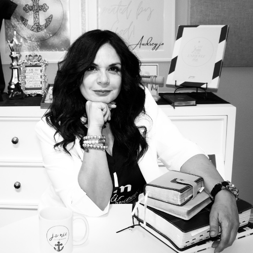 Jewelry designer and life coach at creative workspace with inspirational decor, books, and anchor motif